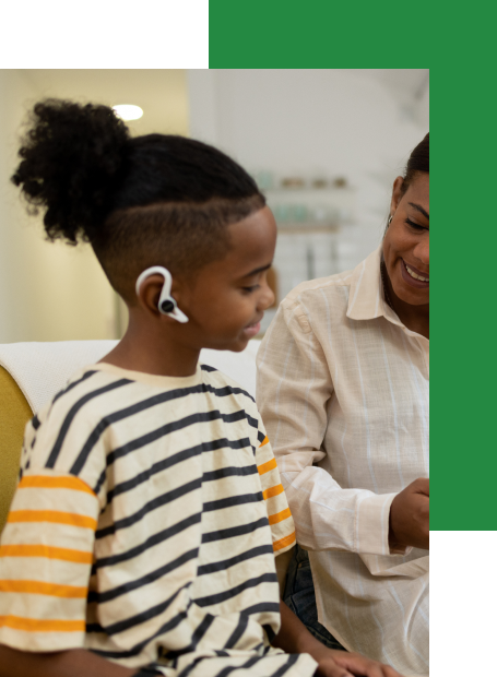 Teacher supporting a deaf child using hearing technology during a virtual learning session.
